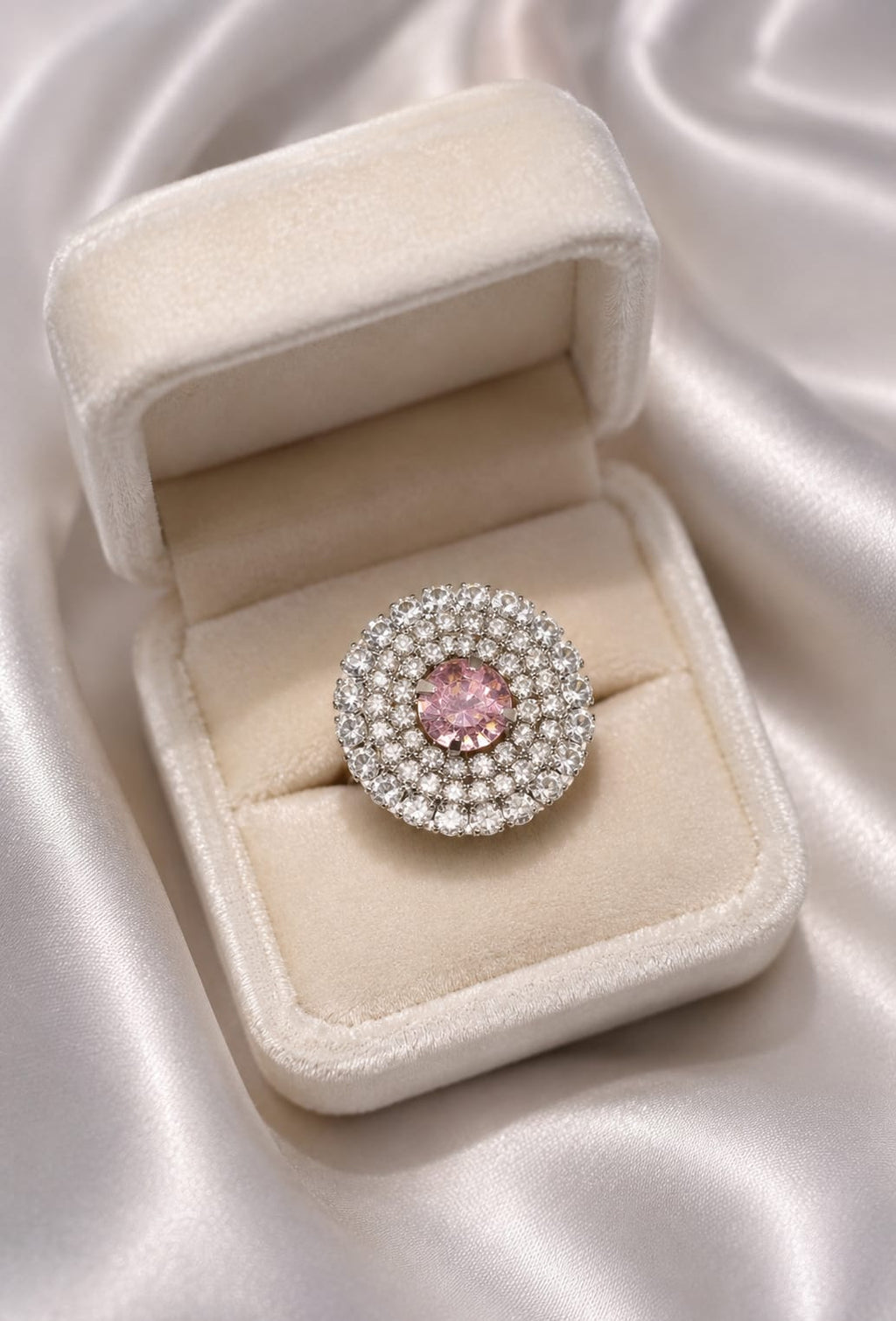 Silver-tone crystal halo ring with round blush-pink center stone, in ring box