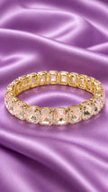 Gold-tone tennis bracelet with oval clear crystals in a line, secure clasp.