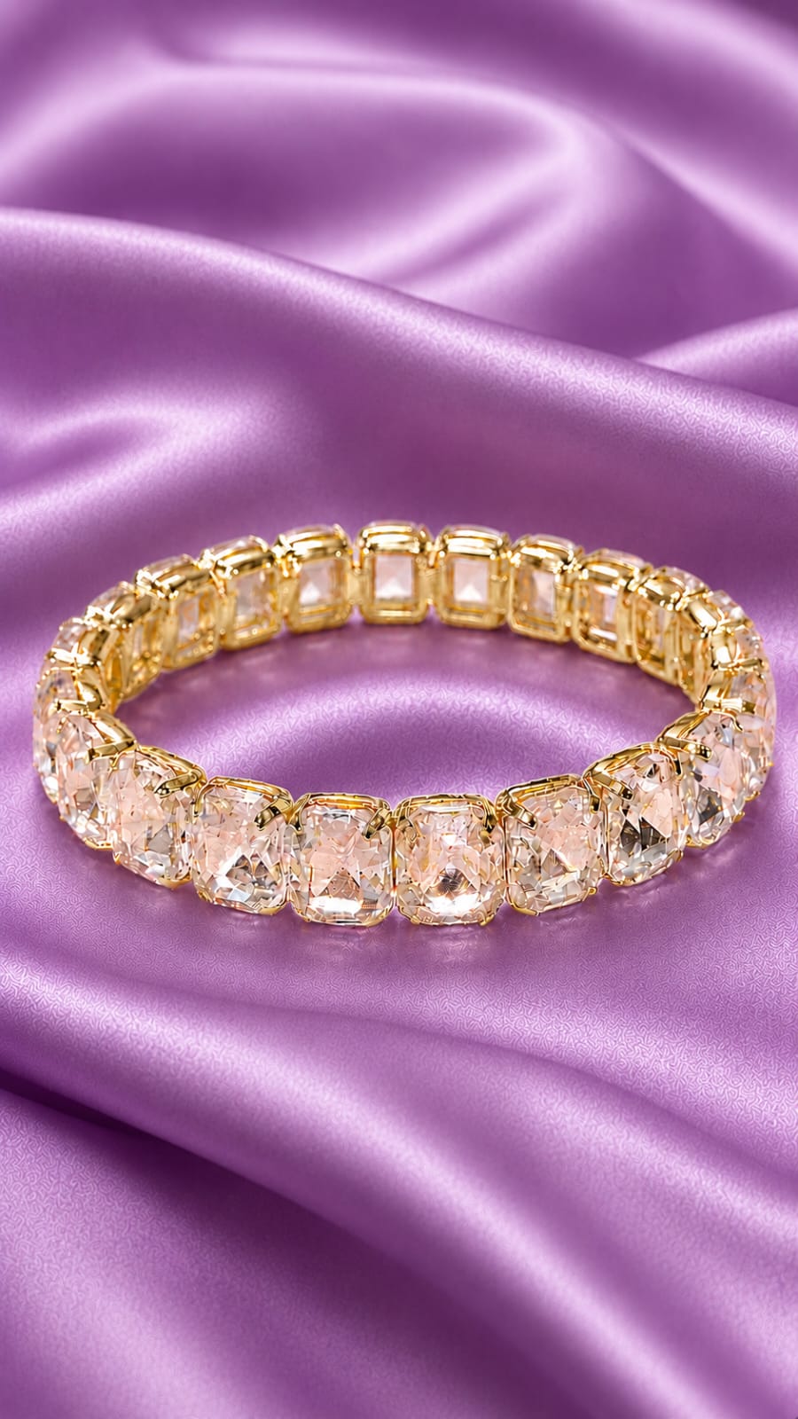 Gold-tone tennis bracelet with oval clear crystals in a line, secure clasp.