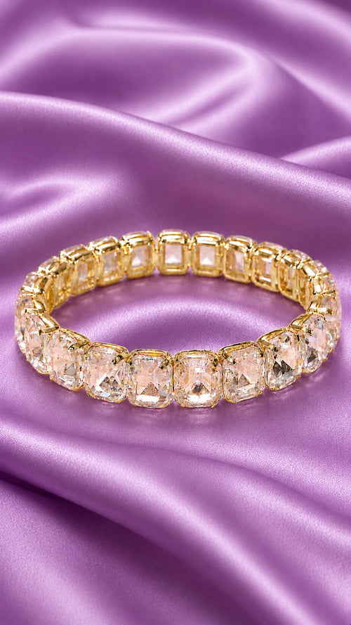 Gold-tone tennis bracelet with oval clear crystals in a line, secure clasp.