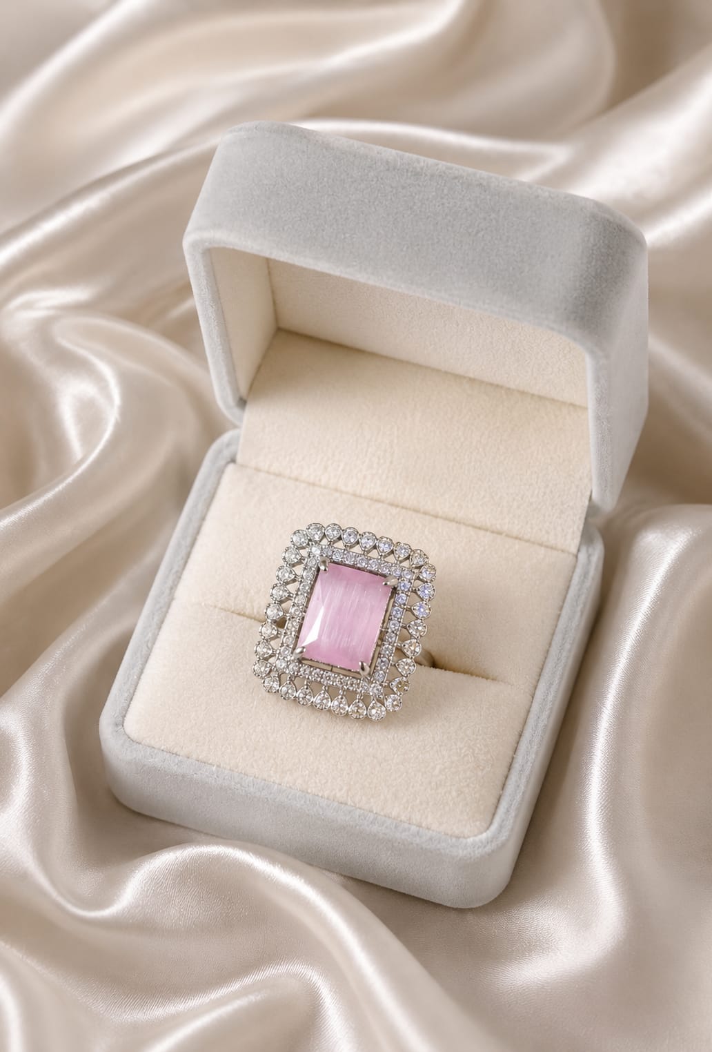 Silver halo statement ring with square blush pink center stone, shown in a gift box