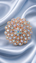 Rose gold floral statement ring with ornate halo of round iridescent blue stones