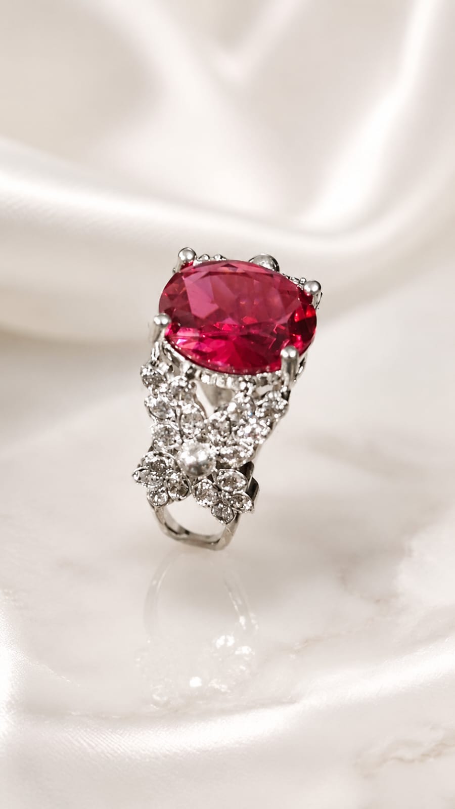 Silver statement ring with large oval red gemstone and textured pave band