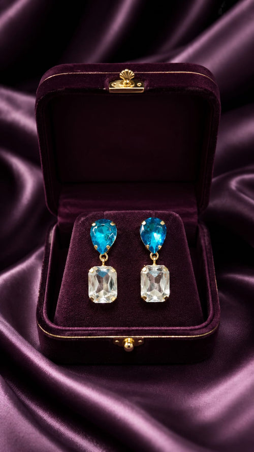 Crystal drop earrings with blue tops and clear dangle stones, shown in velvet case