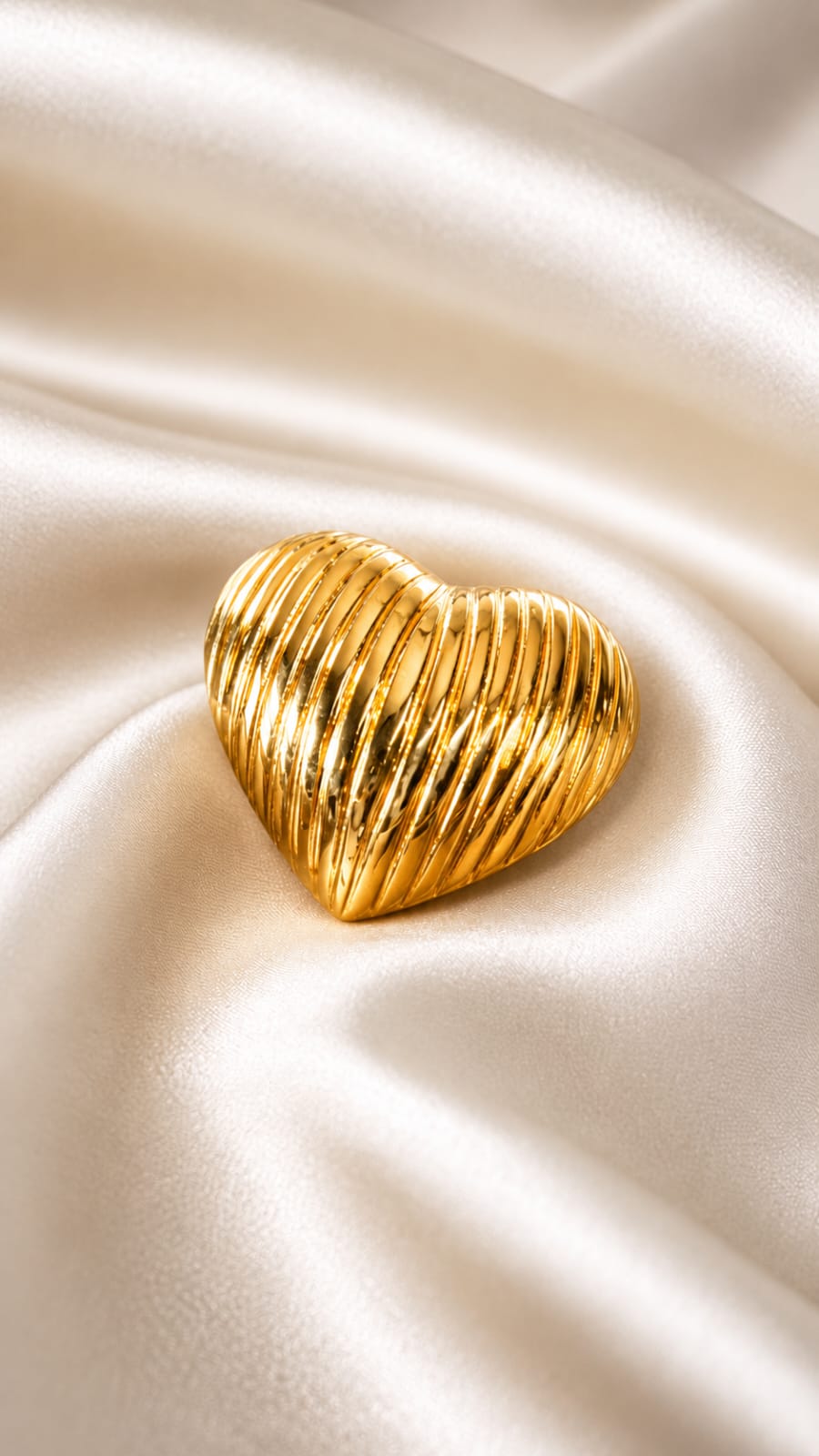 Gold heart statement ring with ridged texture, close-up