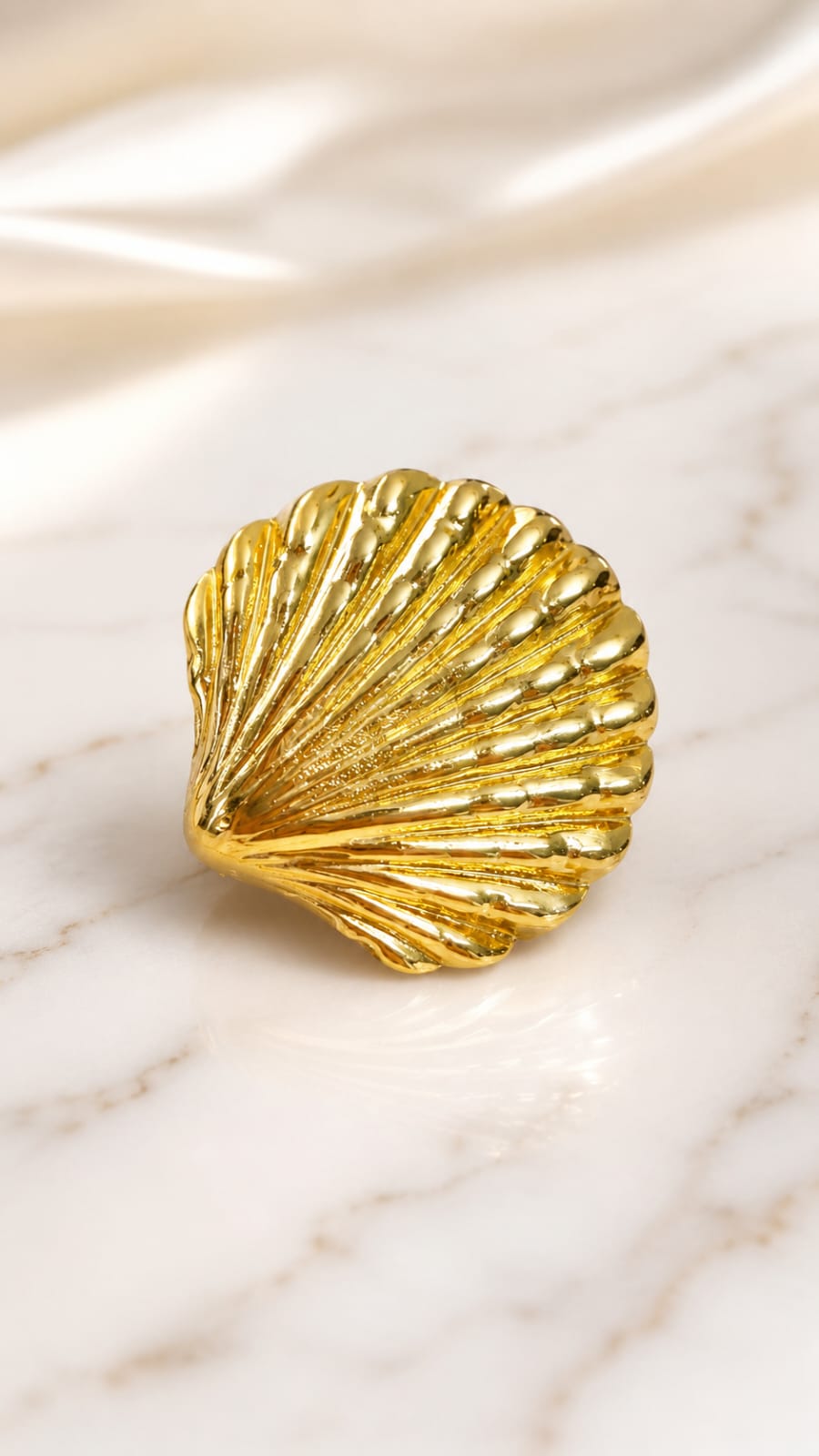 Gold seashell statement ring with ridged shell texture close-up