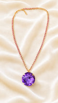 Gold-plated pendant necklace with red jeweled chain and round purple crystal charm
