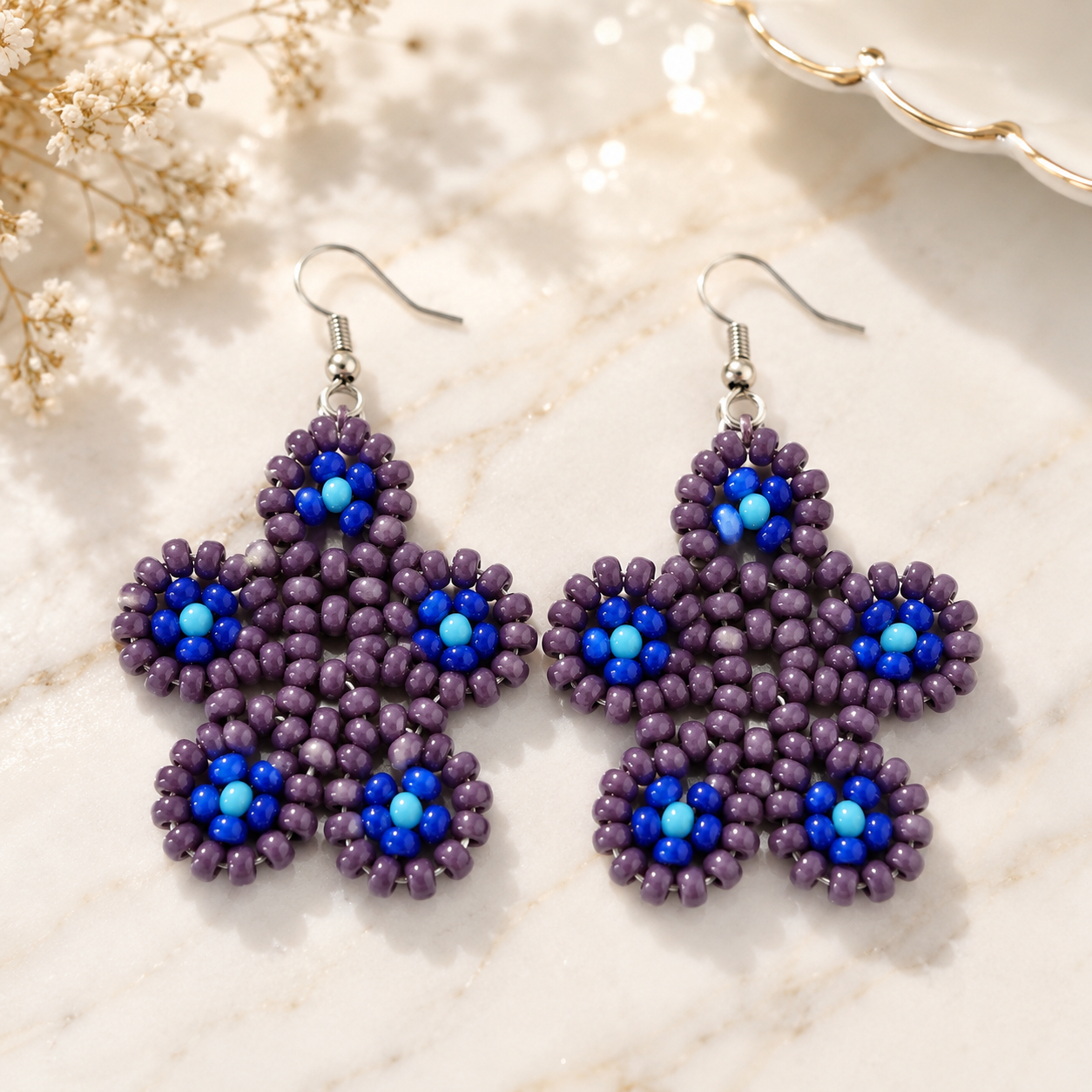 Purple beaded floral drop earrings with blue bead centers and silver hooks