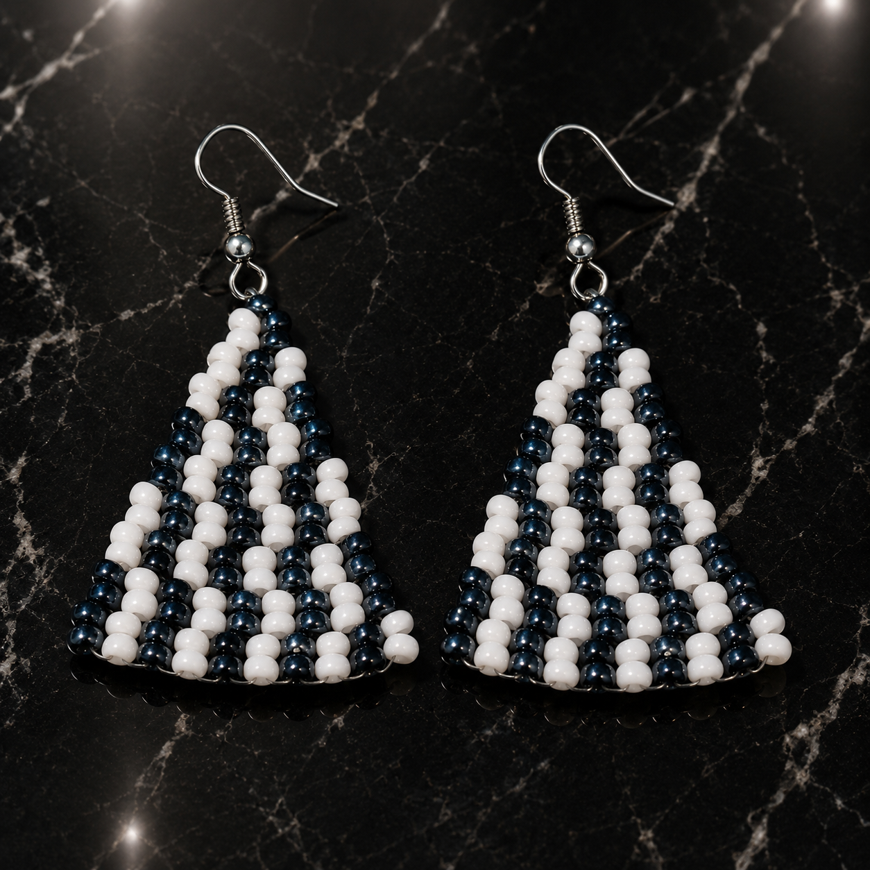 Handmade triangle beaded earrings with white and dark blue beads on silver hooks