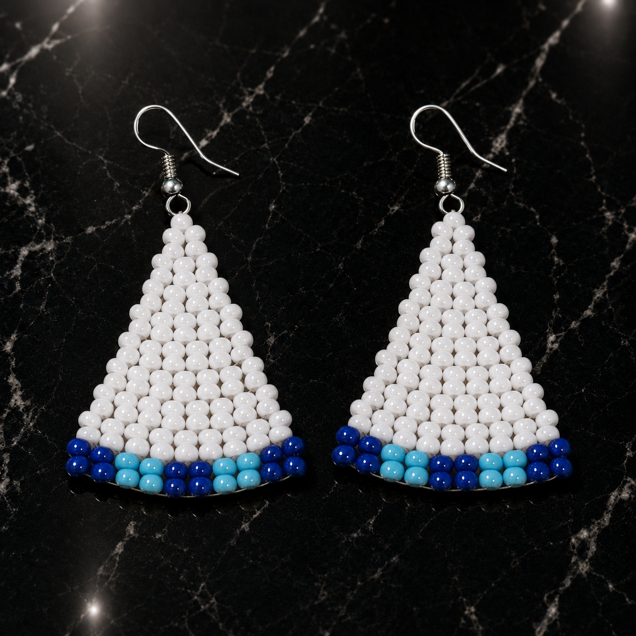 Handmade beaded triangle earrings with white bead body and blue bead band