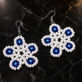 White and blue floral beaded drop earrings with silver hooks.