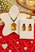 Gold-tone rectangular amber pendant necklace set with green accents and matching earrings