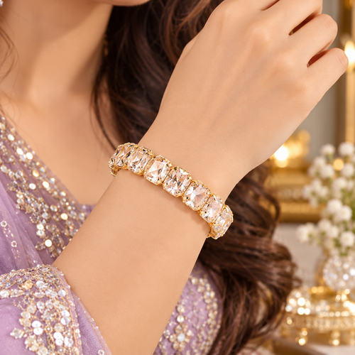 Gold-plated tennis bracelet with sparkling crystal row, shown on a wrist