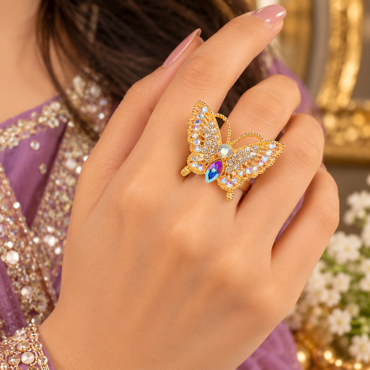Butterfly crystal ring on finger with gold-tone setting and multicolor marquise center