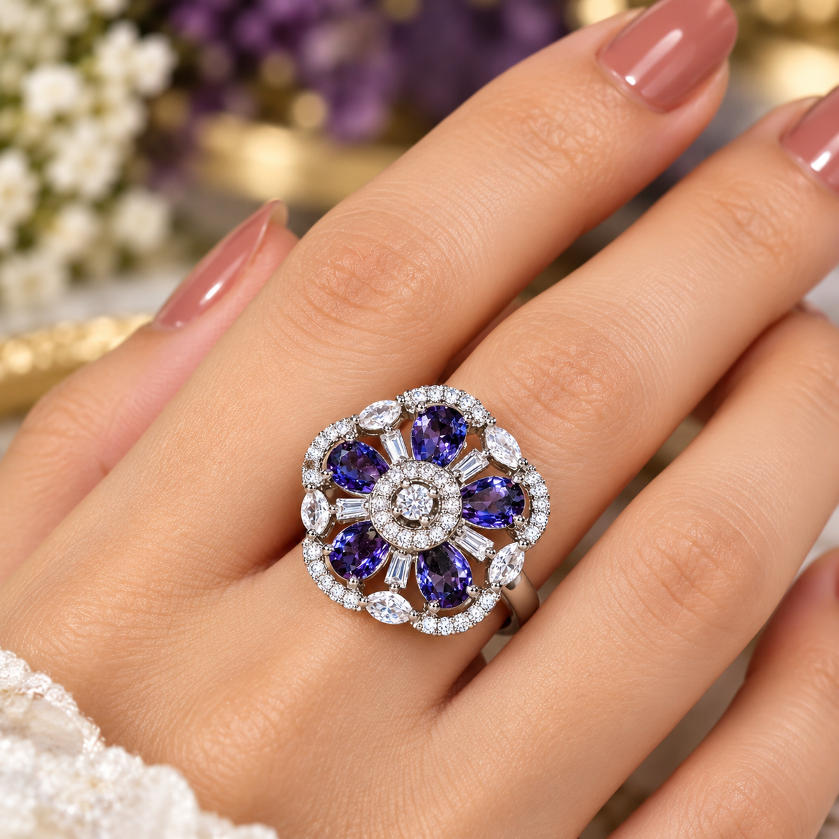 Purple and clear crystal ring on hand, round center with flower-shaped halo