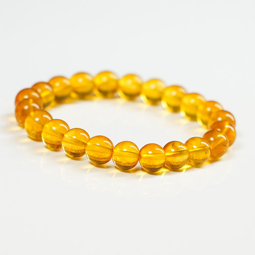 Citrine crystal bracelet with glossy round yellow beads, close-up