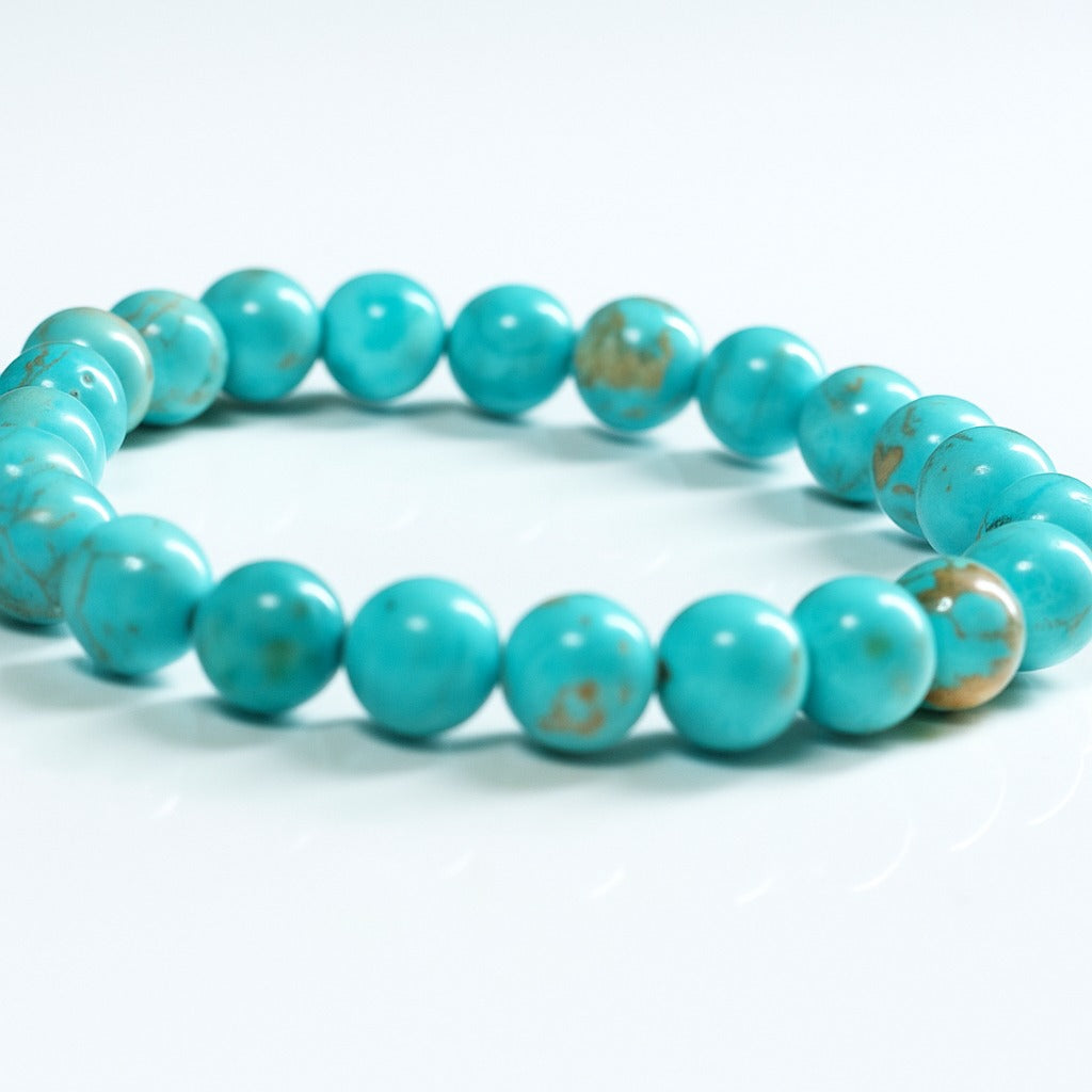 Close-up of turquoise bead bracelet with gold-toned accent beads