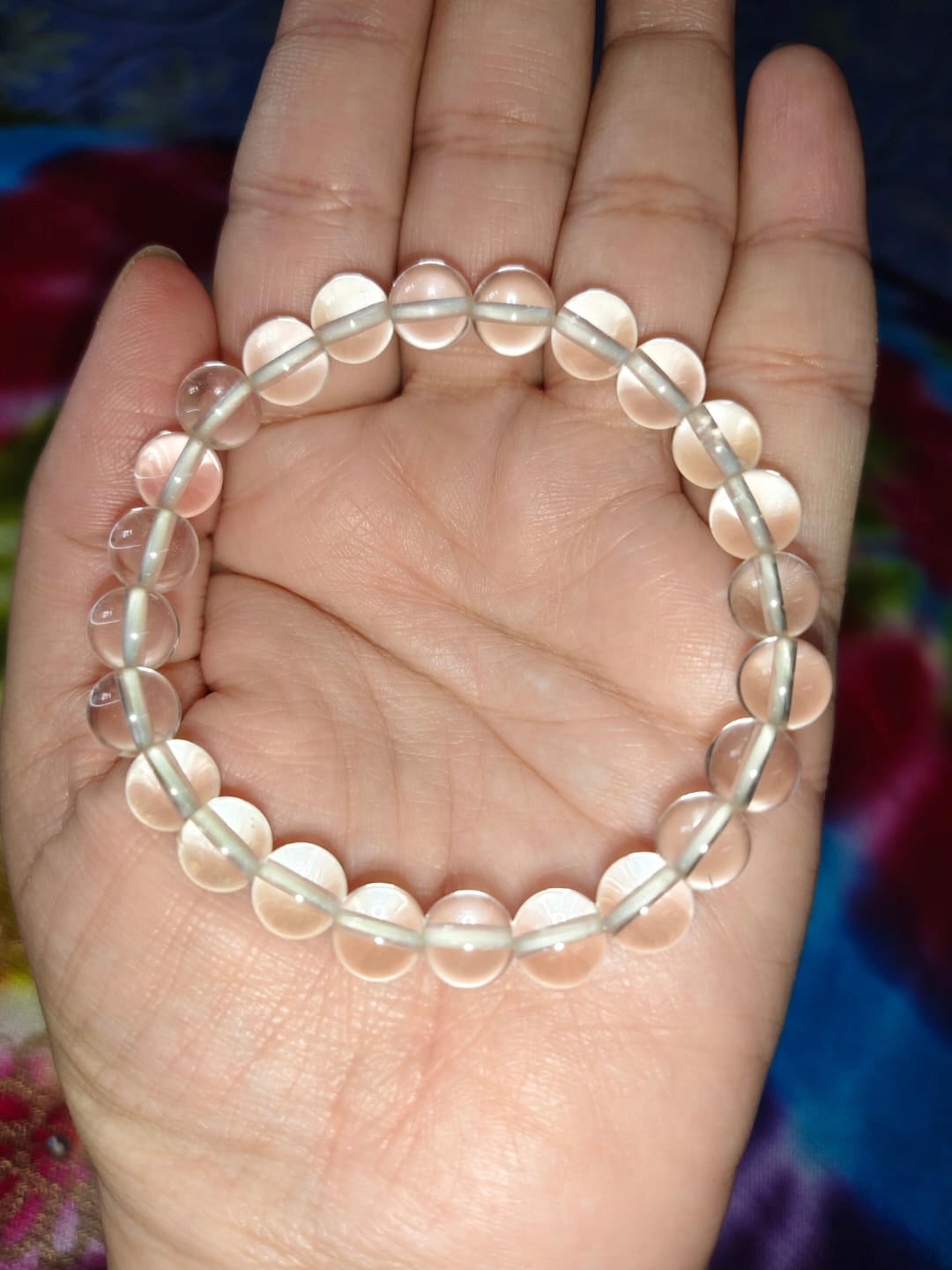 Clear quartz bead bracelet on hand, evenly spaced translucent round beads