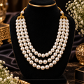 Three-layer pearl beaded necklace with gold-tone clasp and layered pearl strands