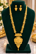 Gold-tone long necklace set with ornate pendant and matching drop earrings.